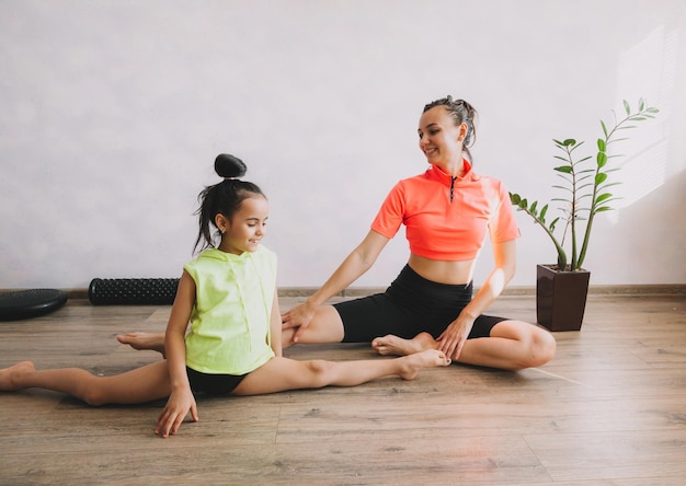 Foto mutter und tochter machen meditation und yoga beim sport und fitness zu hause