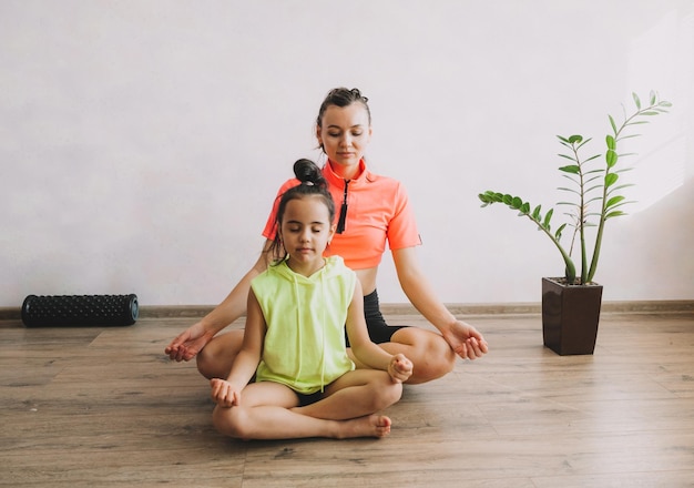 Mutter und Tochter machen Meditation und Yoga beim Sport und Fitness zu Hause