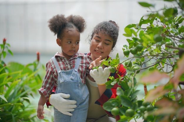 Mutter und Tochter machen Outdoor-Aktivitäten im Garten verschiedene Familien glückliches Mutterschaftswochenende zusammen mit Kind Muttertagskonzept