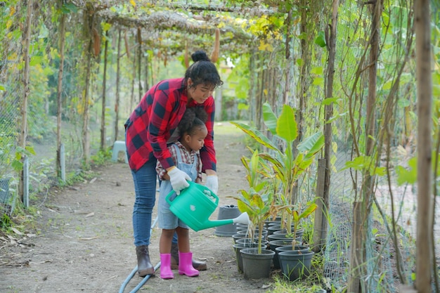 Mutter und Tochter machen Outdoor-Aktivitäten im Garten verschiedene Familien glückliches Mutterschaftswochenende zusammen mit Kind Muttertagskonzept