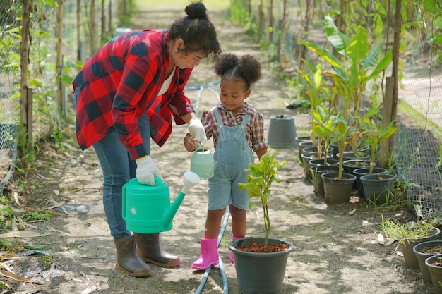 Mutter und Tochter machen Outdoor-Aktivitäten im Garten verschiedene Familien glückliches Mutterschaftswochenende zusammen mit Kind Muttertagskonzept