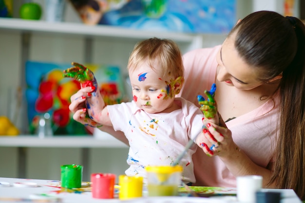 Mutter und Tochter malen auf Leinwand in der Zeichenschule.