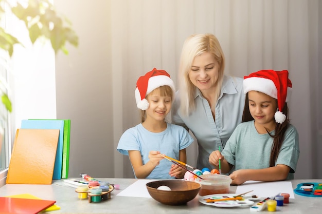 Mutter und Tochter malen Weihnachtsschmuck