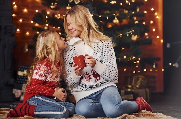 Mutter und Tochter mit Geschenken, die zusammen Weihnachtsfeiertage feiern.