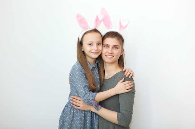 Mutter und Tochter mit Hasenohren auf farbigem Hintergrund