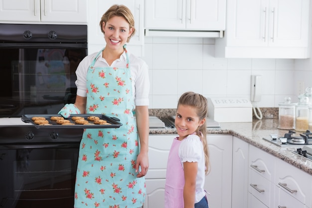 Mutter und Tochter mit heißen frischen Keksen