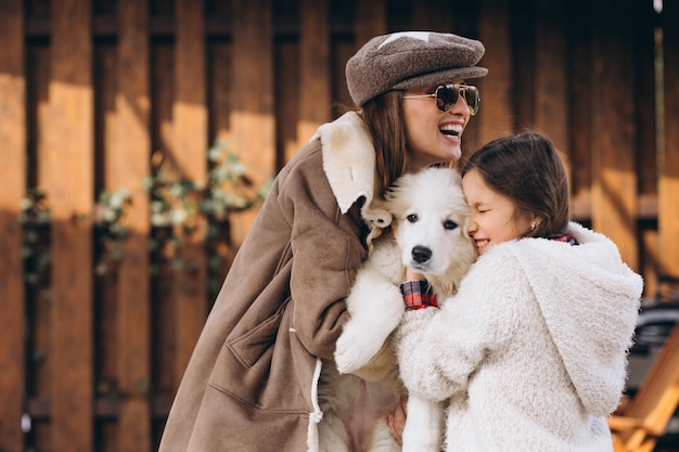 Mutter und Tochter mit Hund draußen