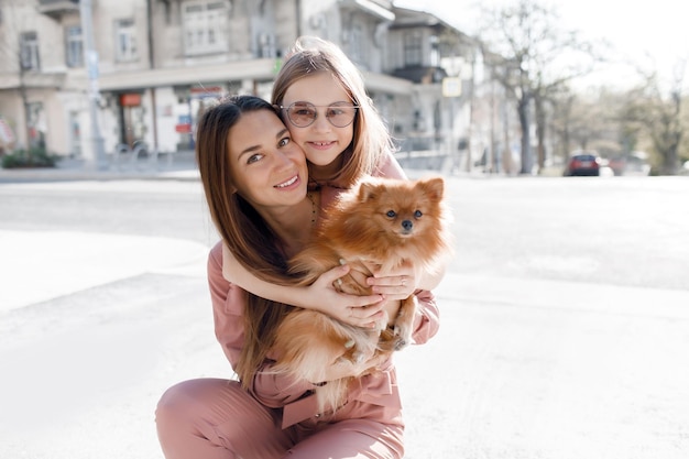 Mutter und Tochter mit Hund im Freien