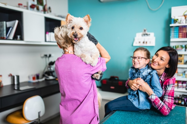 Mutter und Tochter mit ihrem Hund beim Tierarzt.