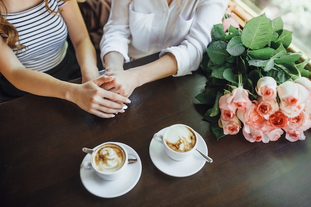 Mutter und Tochter mit Kaffee und Rosen