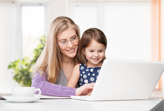 Mutter und Tochter mit Laptop zu Hause