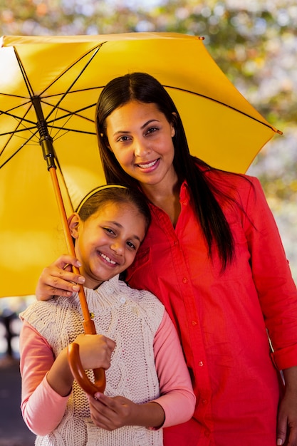 Mutter und Tochter mit Regenschirm im Park