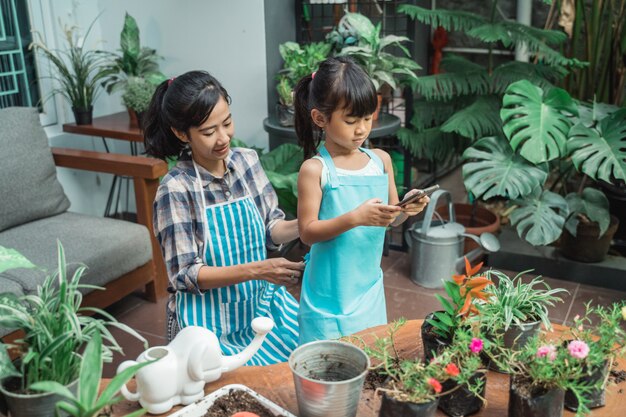 Mutter und Tochter pflanzen zusammen Blume