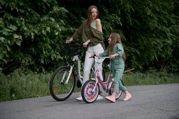 Mutter und Tochter Radfahren im Park Kinder Sommerurlaub Konzept