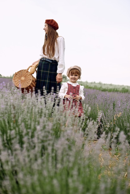 Mutter und Tochter sammeln zusammen Lavendelblüten in einem Korb.