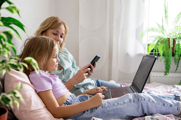 mutter und tochter schauen sich einen laptop an