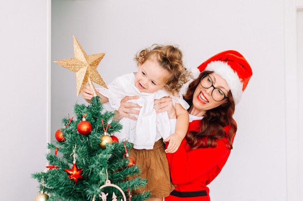 Mutter und Tochter schmücken den Weihnachtsbaum