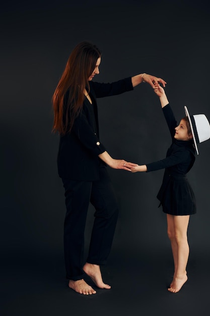 Mutter und Tochter sind zusammen im Studio vor schwarzem Hintergrund