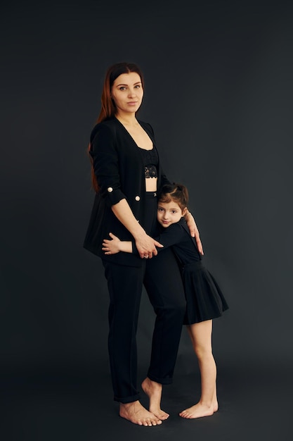 Mutter und Tochter sind zusammen im Studio vor schwarzem Hintergrund