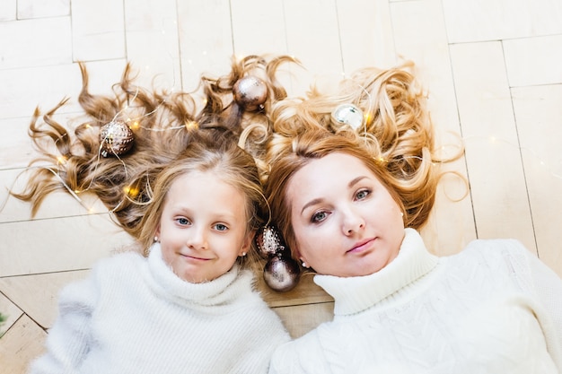 Mutter und Tochter sitzen mit Weihnachtsschmuck