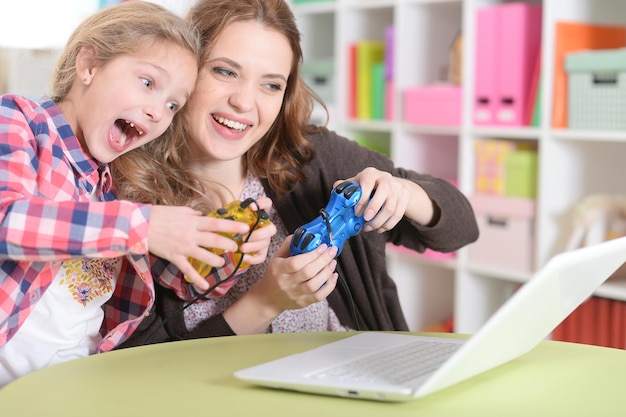 Mutter und Tochter spielen auf dem Laptop