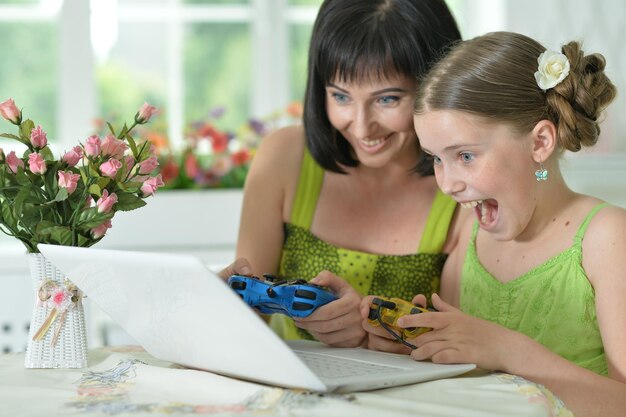 Mutter und Tochter spielen auf einem Laptop