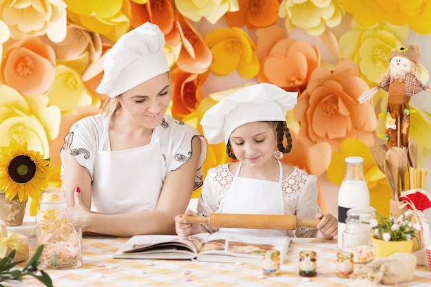 Mutter und Tochter spielen in den Köchen und kochen Abendessen