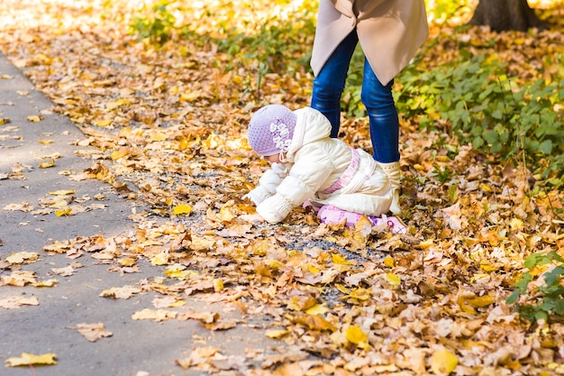 Mutter und Tochter spielen zusammen im Herbstpark.