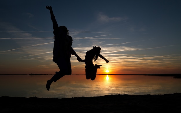 Mutter und Tochter springen Silhouette