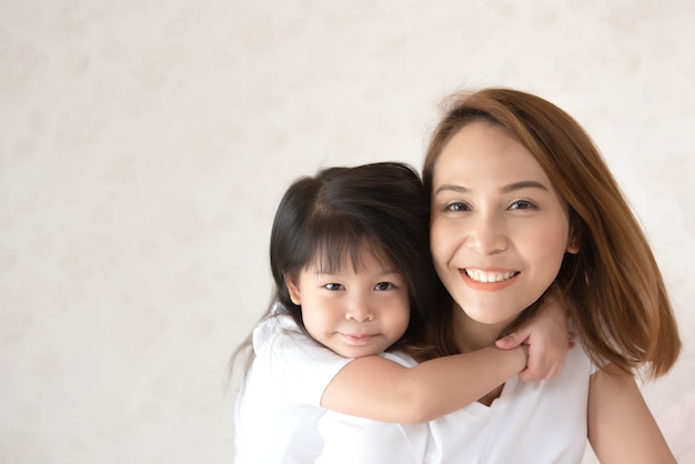 Mutter und Tochter süß, Tochter umarmt schöne asiatische Mutter glücklich lächelnd.