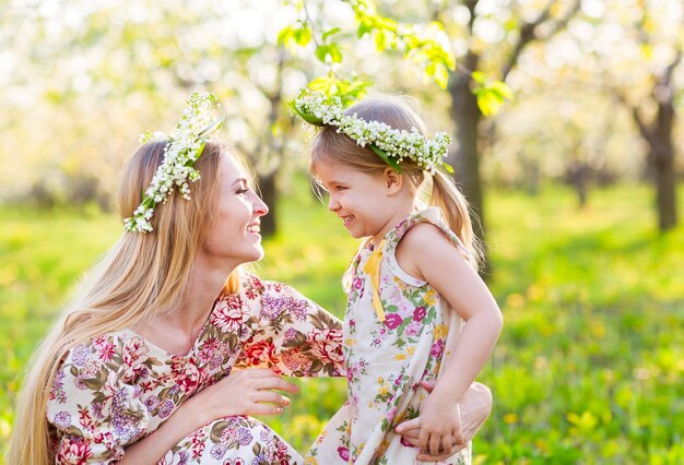 Mutter und Tochter tragen Blumen im Freien