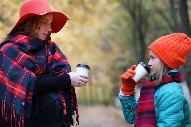 Mutter und Tochter trinken Kaffee im Herbstpark