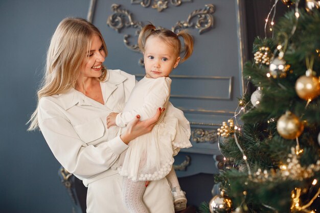 Mutter und Tochter umarmen sich in der Nähe des Weihnachtsbaums