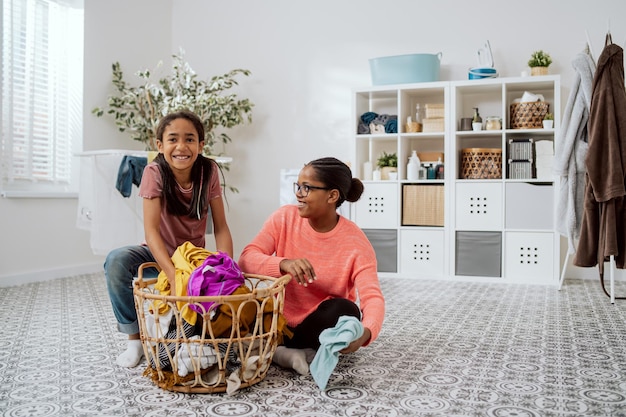 Mutter und Tochter verbringen Zeit zusammen in der Waschküche, während sie bunte Kleidung sortieren