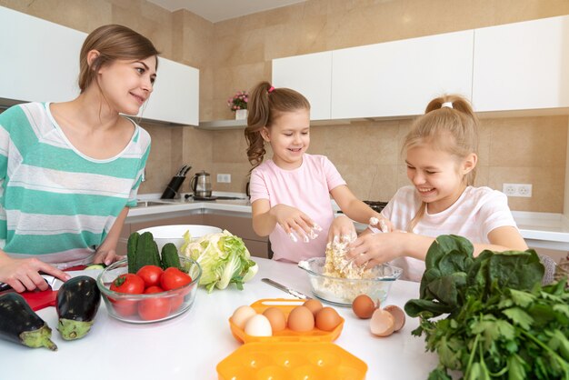 Mutter und zwei Töchter kochen in der Küche und haben Spaß, glückliche Familie und alleinerziehende Mutter Konzept