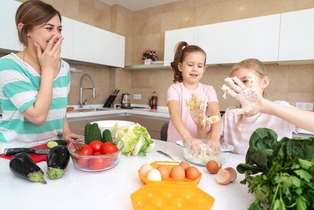 Mutter und zwei Töchter kochen in der Küche und haben Spaß, glückliche Familie und alleinerziehende Mutter Konzept