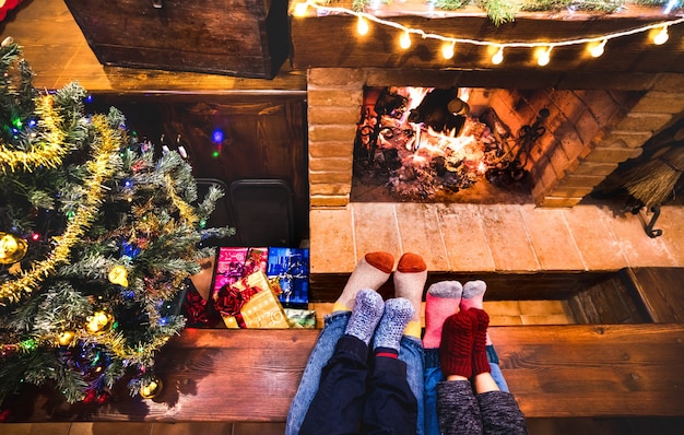 Mutter Vater und Kinder sitzen am gemütlichen Kamin im Winter