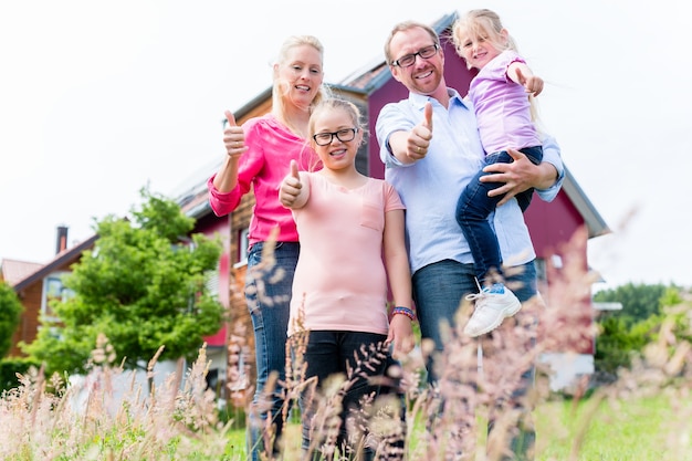 Mutter, Vater und Kinder vor dem Haus