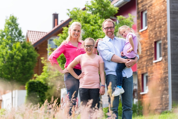 Mutter, Vater und Kinder vor dem Haus