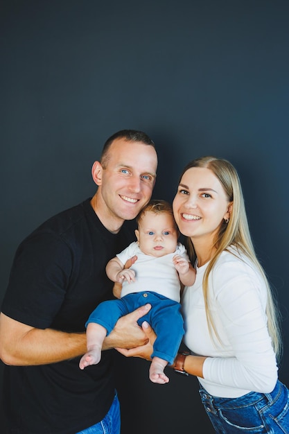 Mutter, Vater und Neugeborenes spielen zu Hause ein glückliches Familienpaar mit einem Kind