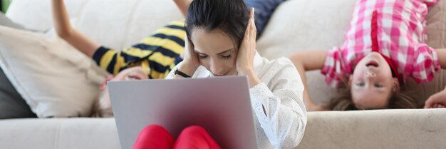 Mutter versucht sich zu konzentrieren und zu arbeiten, während die Kinder verrückt werden und springen