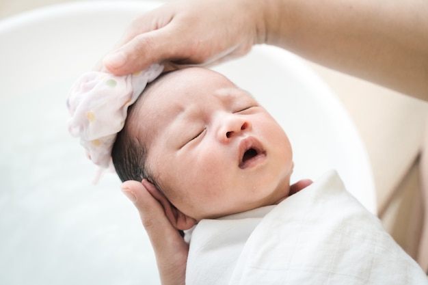 Mutter wäscht Babyhaare. Mutter putzt ihr Babyhaar.