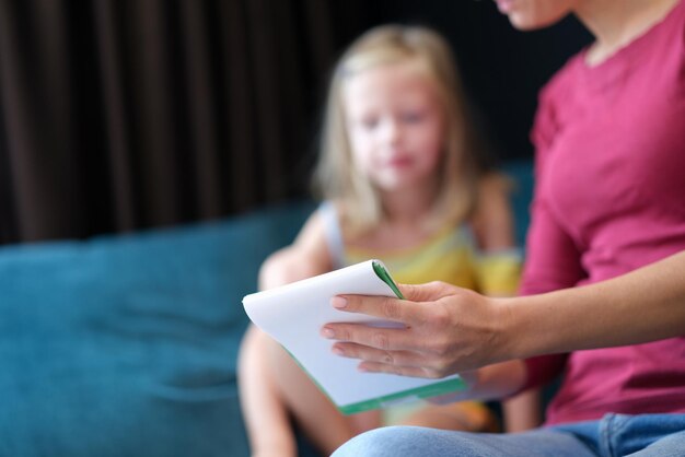 Mutter zeigt Lernnotizbuch für Tochterkonzept