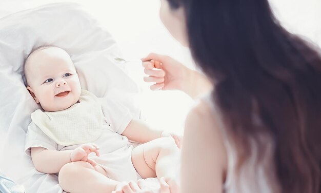 Mutterschaftskonzept Eine junge Mutter füttert ihr kleines Baby Erste Köder und Stillen Große Familie in weißer Kleidung