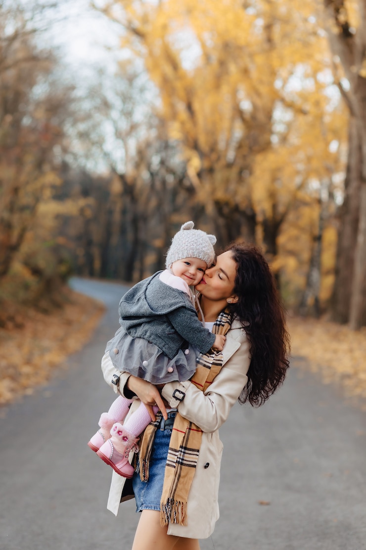 Foto mutterspiel der jungen frau mit kleiner tochter an der herbstparkstraße