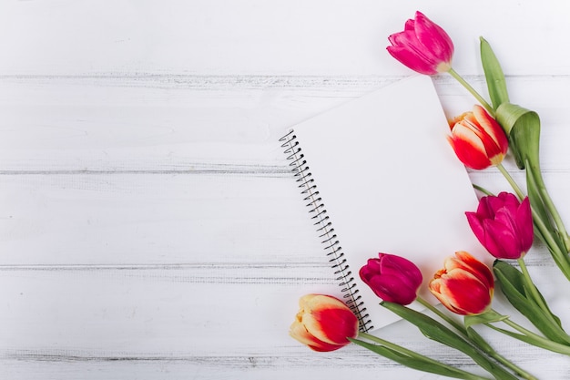 Foto muttertag. rosa tulpen und notizbuch mit exemplarplatz.