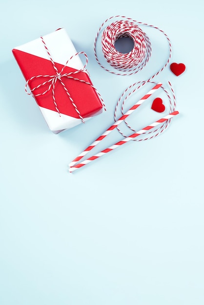 Muttertag Valentinstag handgefertigtes Geschenk-Design-Konzept Verpackte Geschenkbox isoliert auf pastellhellblauem Hintergrund flach Draufsicht