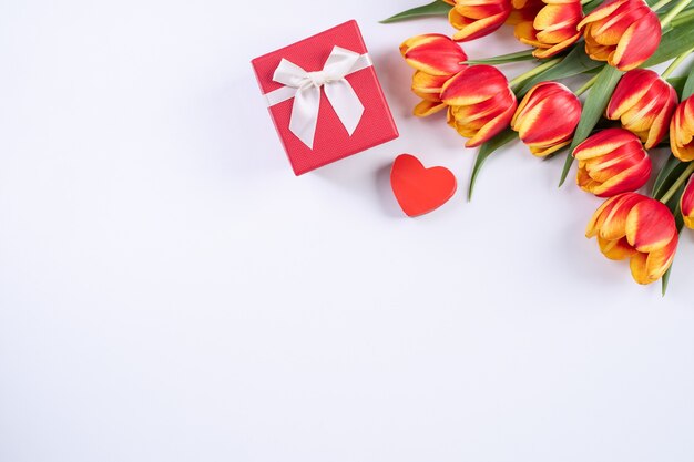 Muttertag, Valentinstag Hintergrund, Tulpenblumenstrauß - Schöner roter, gelber Blumenstrauß einzeln auf weißem Tisch, Draufsicht, flache Lage, Mock-up-Designkonzept.