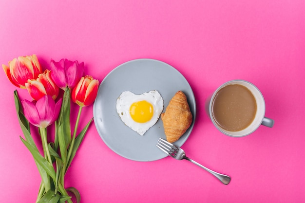 Muttertag zusammensetzung. frühstück mit tulpen auf rosa hintergrund.