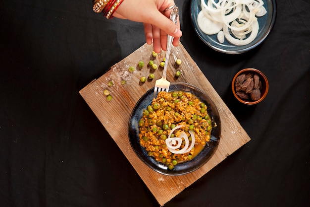 Mutton Keema, comida india, cebolla, tazones y platos con vista superior de comida india